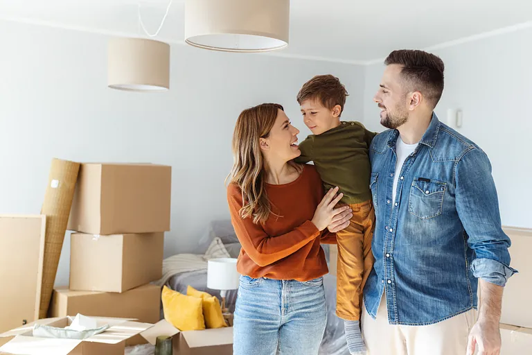 Glückliche Familie beim Umzug in ein neues Zuhause mit Umzugskartons im Hintergrund – Unterstützung durch ein professionelles Umzugsunternehmen in Bad Salzungen.