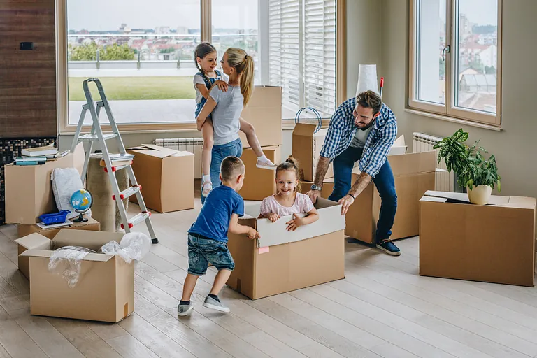 Glückliche Familie mit Kindern beim Einzug in ihr neues Zuhause – Privatumzug in Eisenach mit Umzugskartons und Vorfreude.